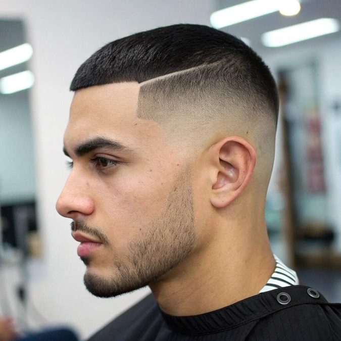 A man with a sharp, precise professional box haircut