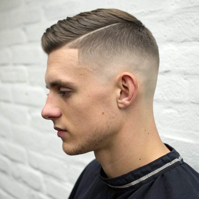 Buzz cut with clean low taper and natural temple