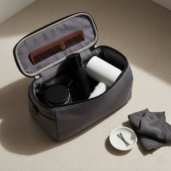 Compact men’s travel hair styling kit with mini paste, pocket comb, and travel hairspray in a dopp kit.