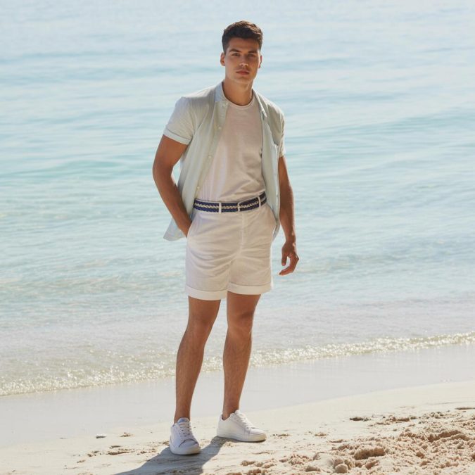 summer men’s outfit with linen shorts and woven statement belt, white tee and clean sneakers
