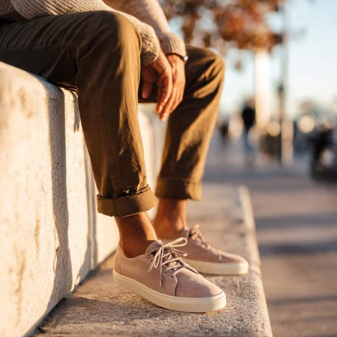 man sitting outdoors wearing minimalist knit sneakers with casual trousers showing relaxed diabetic footwear mens outfit