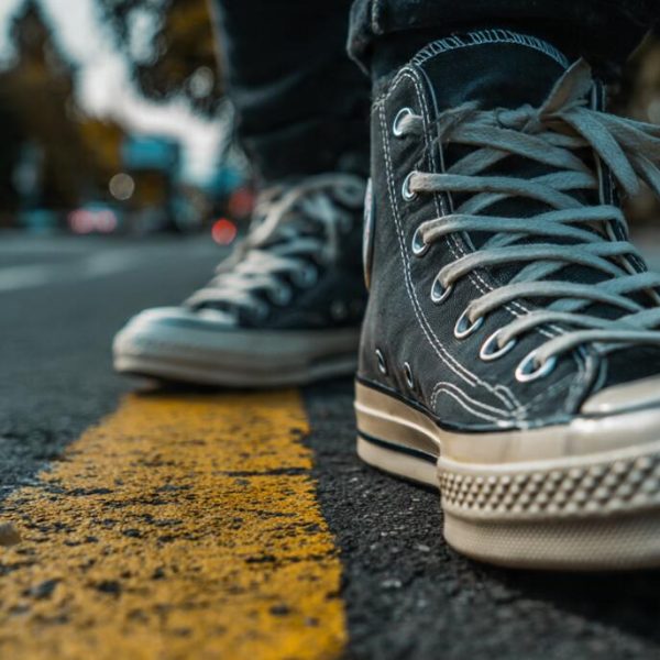A man wearing white leather casual shoes and jeans working in a coffee shop, illustrating the 2026 guide to mastering casual style and comfort.