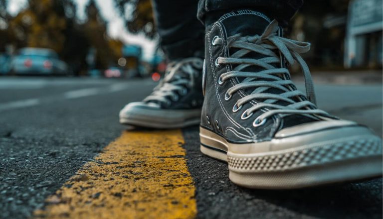 A man wearing white leather casual shoes and jeans working in a coffee shop, illustrating the 2026 guide to mastering casual style and comfort.