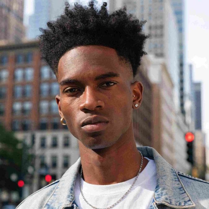 Afro taper fade haircut featuring natural texture and neatly blended sides.