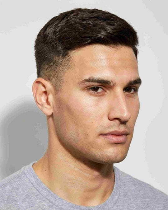 Man with a classic crew cut featuring a graduated top and tapered sides.