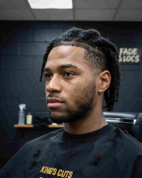 Black man with locs and an undercut, creating a modern contrast between length and clean sides.