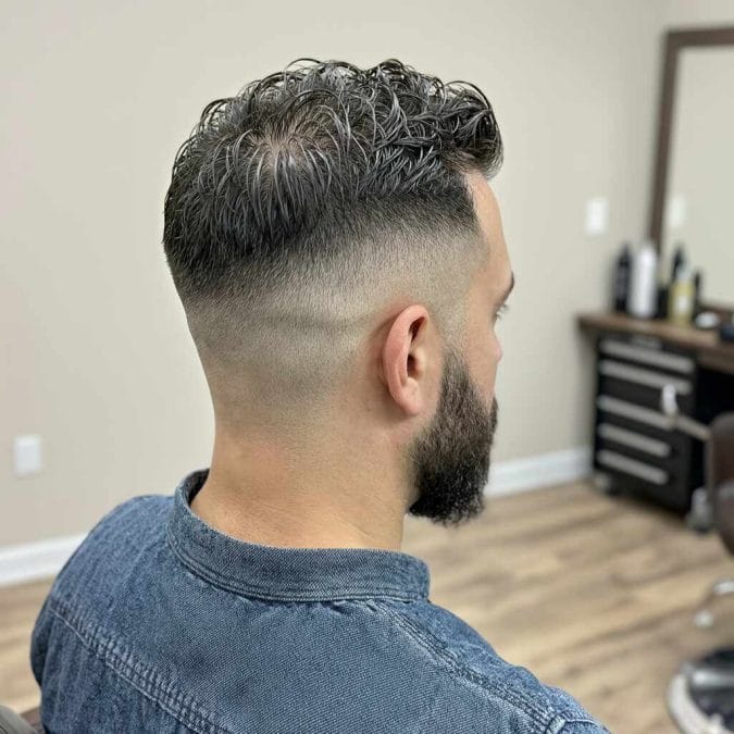 Rear view of a low fade with a textured top and visible crown movement.