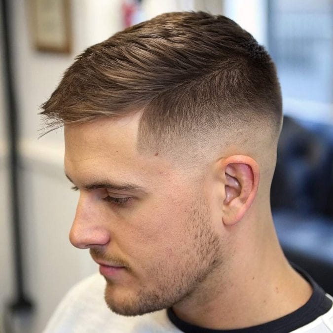 Man with a short side-swept crop, faded sides, and hair directed diagonally across the front.