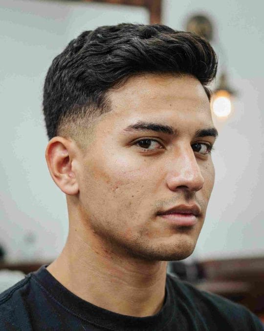 Short wavy taper with neat sides and soft texture on top.
