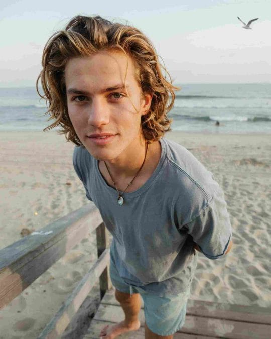 Surfer-style wavy hair with loose beach texture and natural flow.