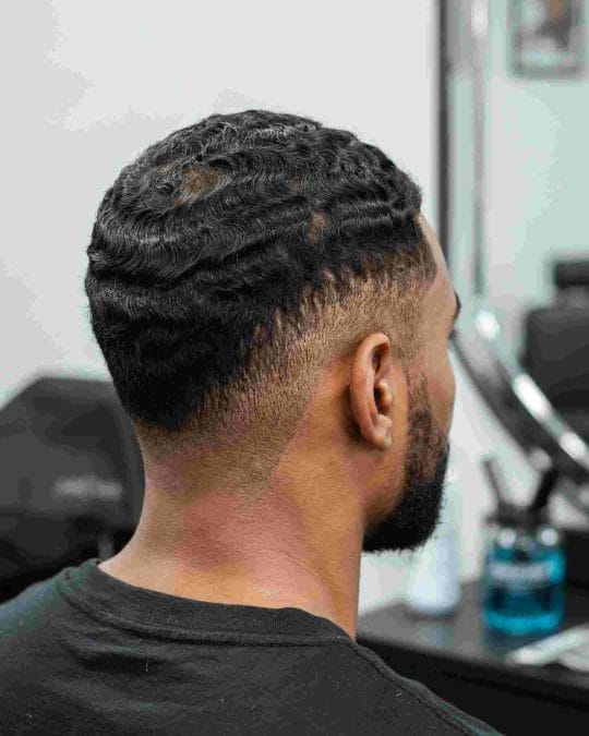 Wavy low fade with natural texture and clean sides.