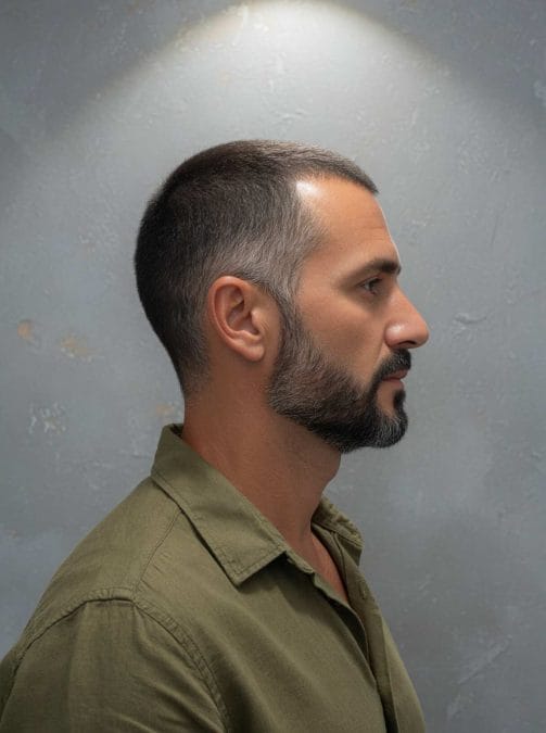 Crew cut with short beard and salt-and-pepper hair.