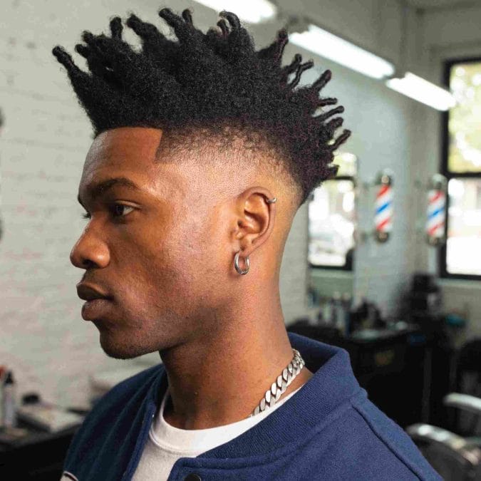 Black man with a frohawk fade hairstyle featuring natural volume and faded sides.