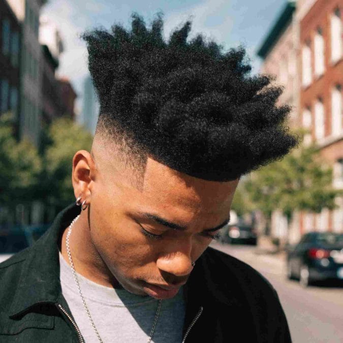 High fade haircut with a kinky textured top that adds height, shape, and natural volume.