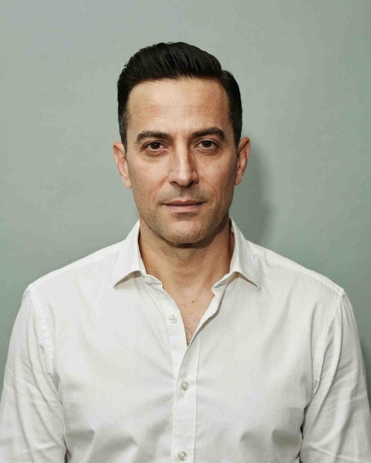 Man over 40 with a short pompadour and textured top.