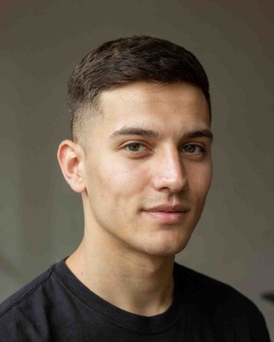 Man with a short crew cut and tapered sides.