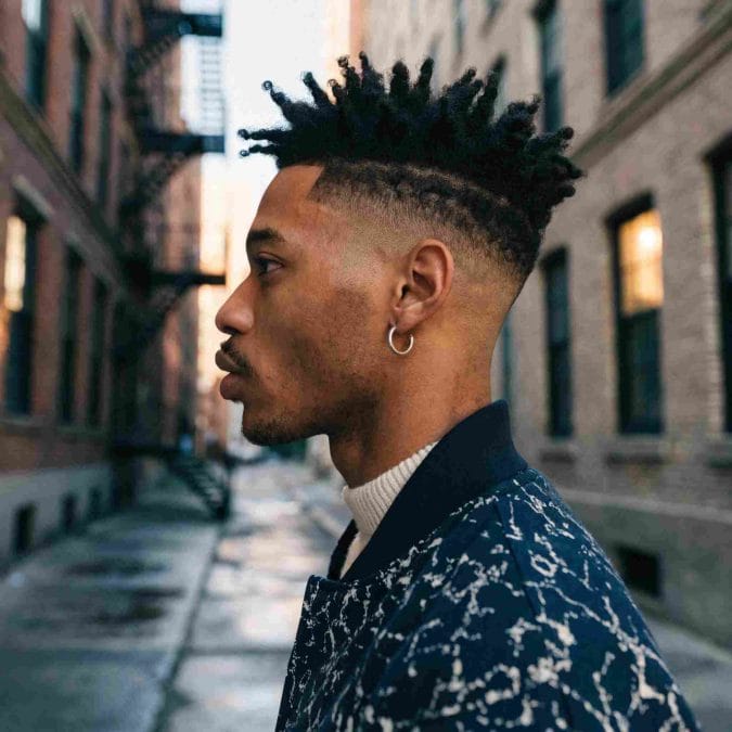 Skin fade with a sharp line up, clean sides, and a defined beard blend.