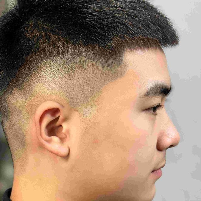 Man with a taper fade crew cut and neat textured top.