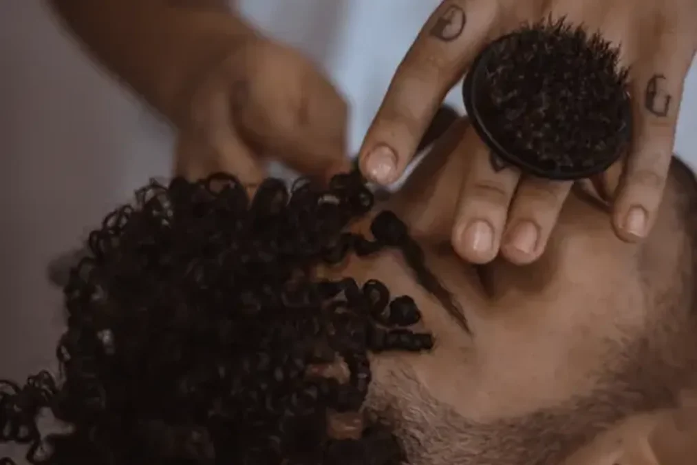 Barber styling a man's curly hair