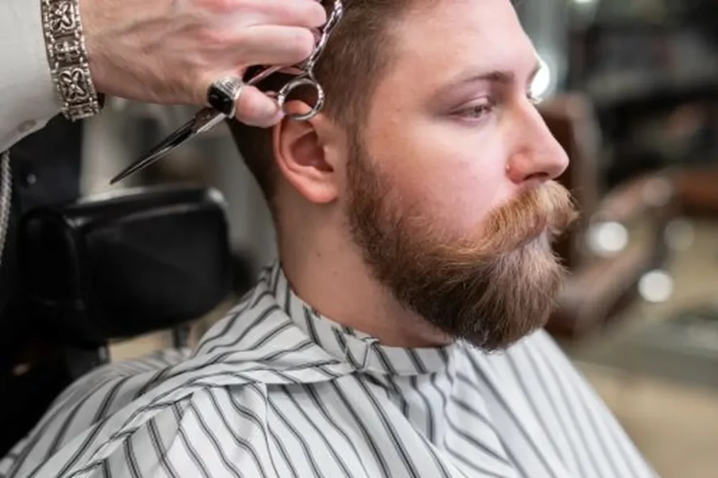 Crew cut: a barber trimming hair in a classic barbershop.