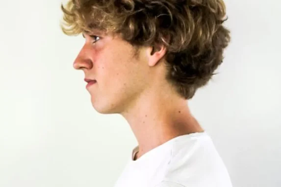 curly haircuts for men: side profile of a man with curly hair